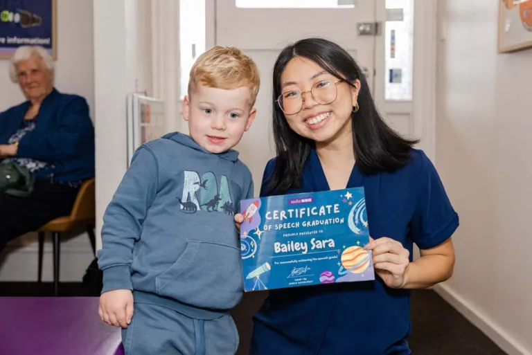 A speech therapy patient being awarded a certificate of graduation, celebrating progress achieved through SASHC’s expert speech pathologists