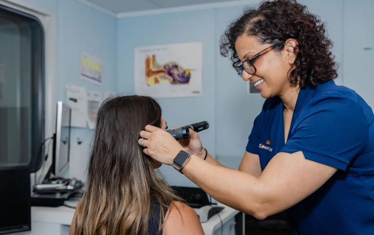 An audiologist performing an ear examination on a patient at South Australia Speech and Hearing Centre