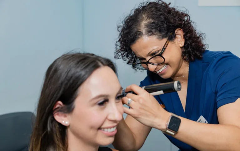 An audiologist examining a patient’s ear with an otoscope at South Australia Speech and Hearing Centre