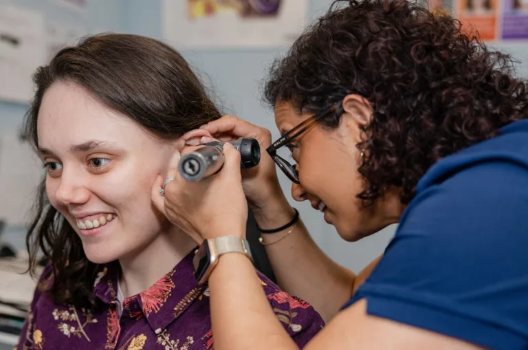 An audiologist using an otoscope to examine a patient’s ear at South Australia Speech and Hearing Centre