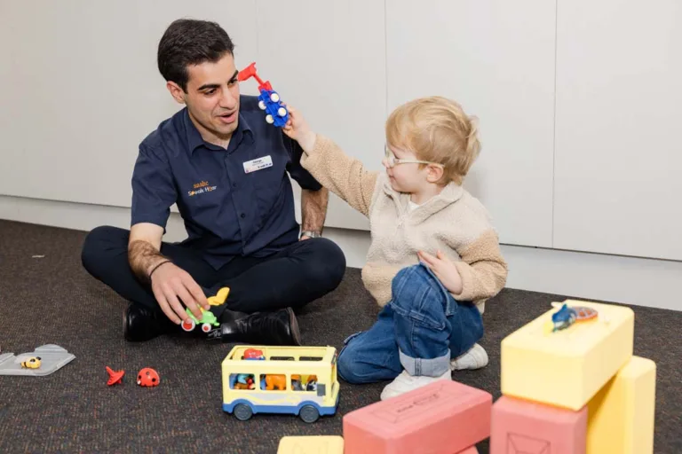 A child and speech therapist playing with toy trucks during a speech therapy session at South Australia Speech and Hearing Centre