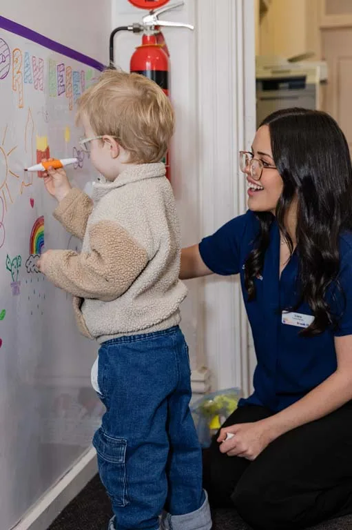 A child drawing with markers during a creative speech therapy session at South Australia Speech and Hearing Centre