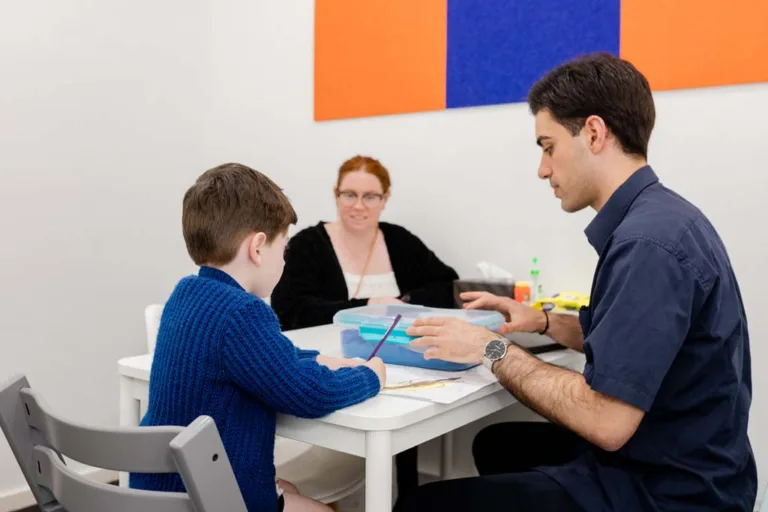 A child receiving speech therapy with their mother present, guided by a speech pathologist at South Australia Speech and Hearing Centre
