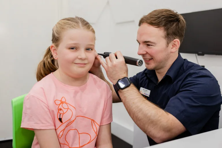 An audiologist examining a child’s ear as part of a hearing test at South Australia Speech and Hearing Centre