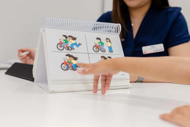 A speech therapy patient pointing at a picture during an interactive session with a speech pathologist at South Australia Speech and Hearing Centre