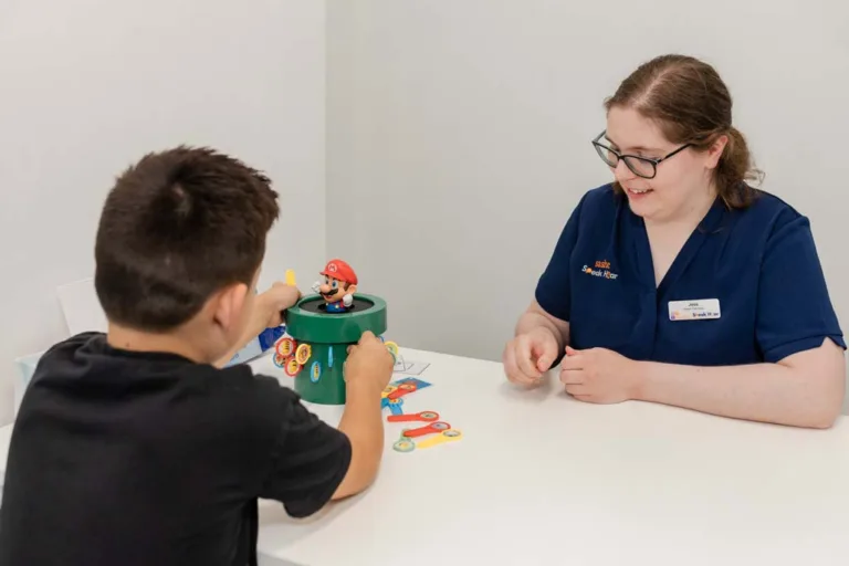 A child receiving speech therapy using a Super Mario toy, guided by a speech therapist at South Australia Speech and Hearing Centre
