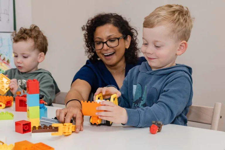Children receiving speech therapy by playing with toy trucks, guided by a speech pathologist at South Australia Speech and Hearing Centre