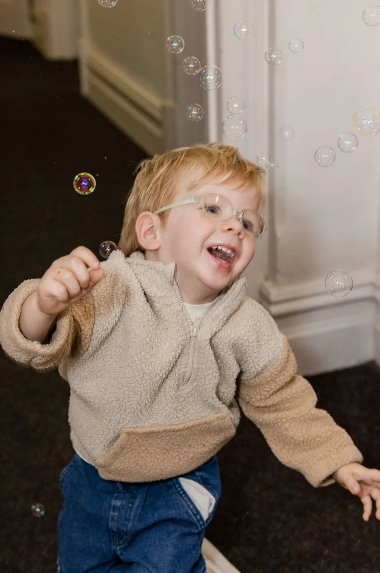 Child Playing with Bubbles at SASHC Child playing with bubbles during a session at SASHC